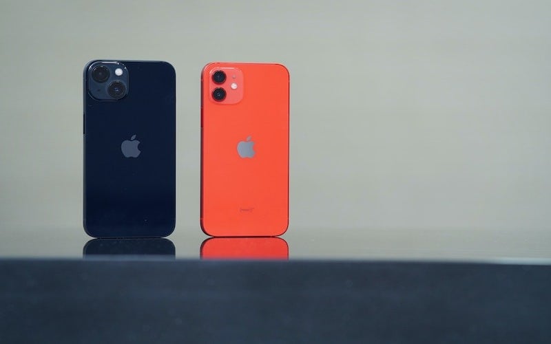 a blue iPhone 12 next to a red iPhone 13