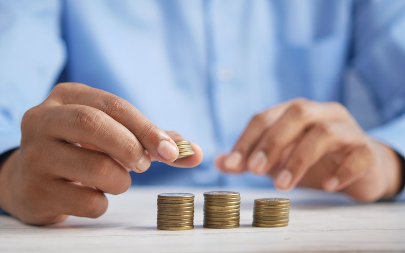 person counting their coins in piles