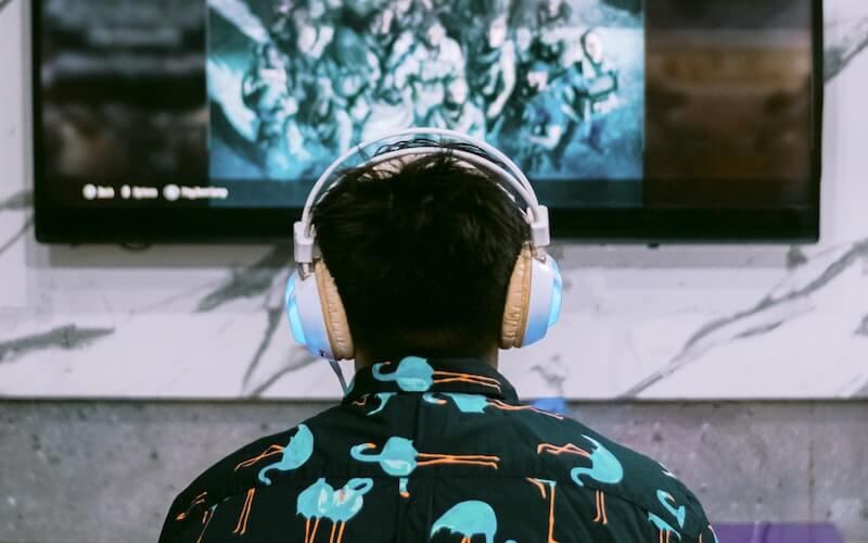 man with headset on playing best gaming console for him